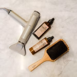 healthy scalp products flat lay with serums scrubs and oils on a clean white surface